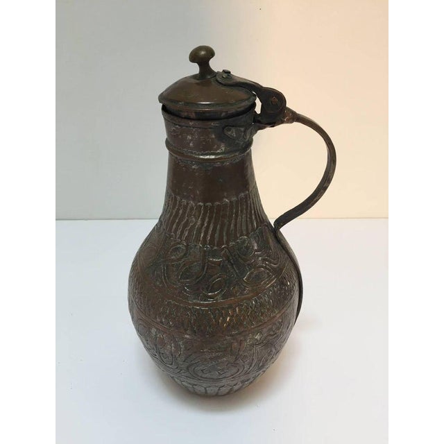 19th century Middle Eastern Arabian tinned copper ewer with lid. Hand-hammered and chased copper with geometric design and...