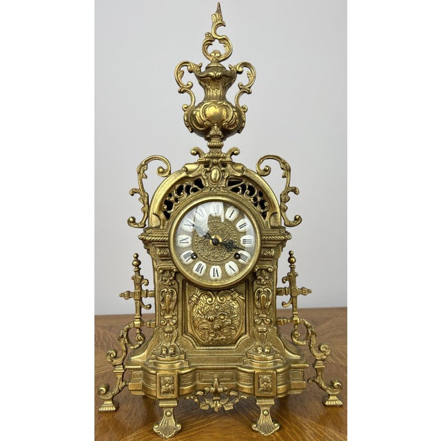 A beautifully detailed Vintage brass clock with an ornate decorative design and elegant period styling throughout. This...