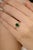 This vintage style ring is crafted in 14k yellow gold, showcasing a 1.23-carat oval cut emerald at the center. Surrounding...