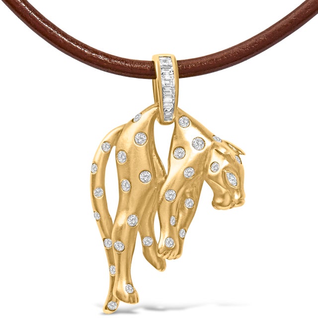 Immerse yourself in the whimsical elegance of this meticulously crafted 18K gold pendant, shaped like a cat and delicately...