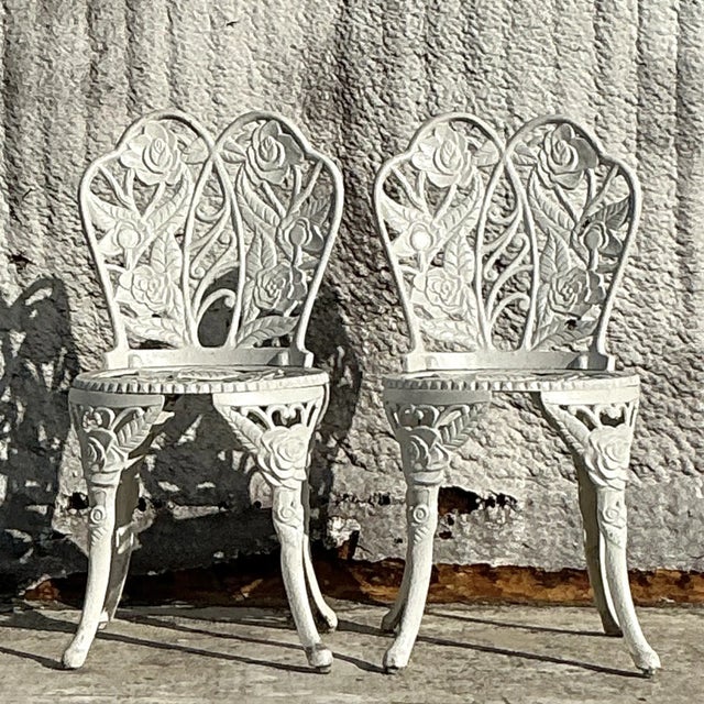 This charming vintage Regency-style wrought iron set includes a round table and two matching chairs, all featuring...
