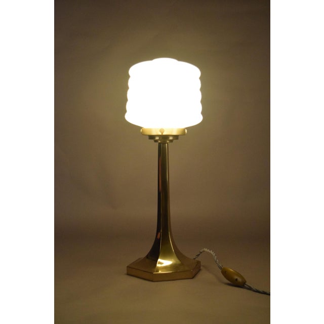 A beautifully proportioned Josef Hoffmann–style table lamp, combining a sculptural brass base with a stepped,...