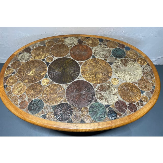 Beautiful oval teak coffee table with artistic ceramic in the top in very nice used condition. The artist has signed his...