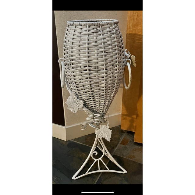 This adorable vintage white wicker urn/vase and wrought iron plant stand is in excellent condition. The wicker urn/vase is...