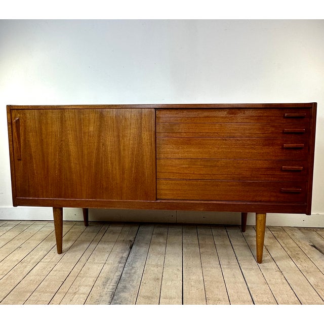 Small vintage Scandinavian teak sideboard dating from the 1960s. Its clean and timeless design is characterized by simple...