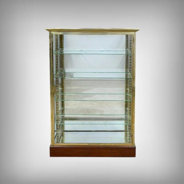 A magnificent brass display case with a hinged glass door, complete with its original, fully functional lock and key. The...