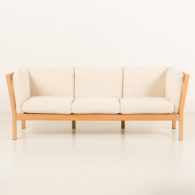 This danish mid-century sofa has a solid beech frame and is reupholstered with new natural linen fabric in light ivory....