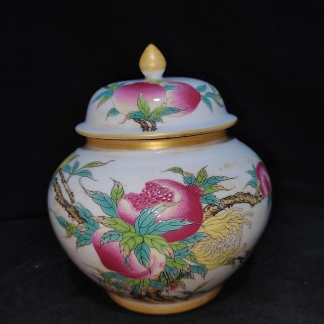 A beautiful pair of Chinese Famille Rose porcelain covered jars. The white ground is finely hand-painted with vibrant pink...