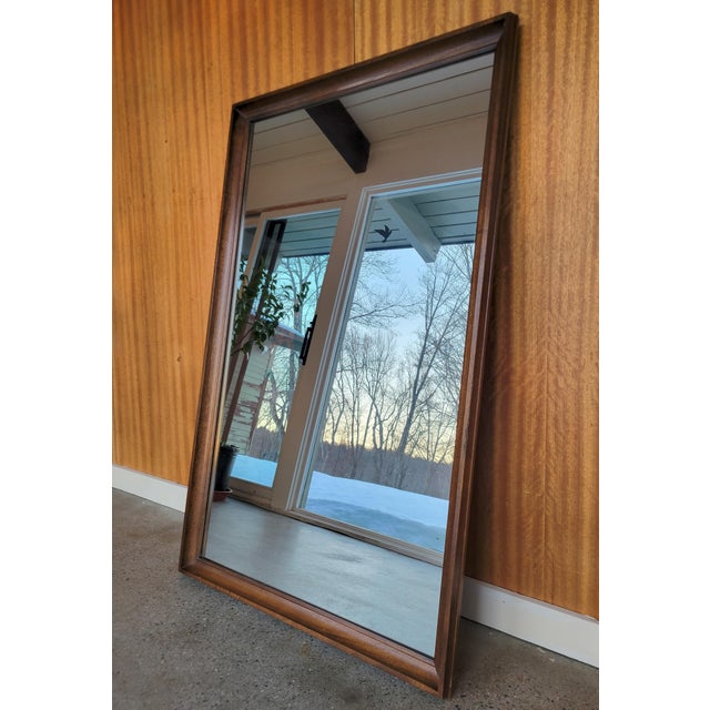 Mid Century Modern Walnut Wall Mirror, 1960’s, the Strata for Unagusta. The mirror is a striking example of 20th century...