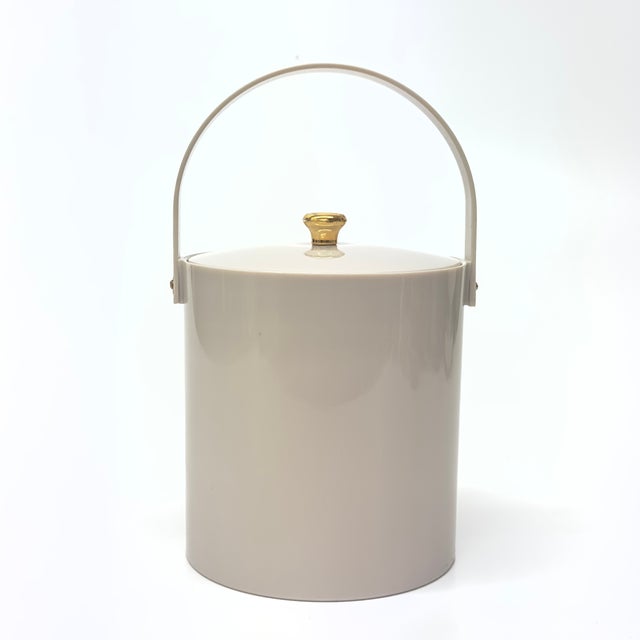 Taupe ice bucket. This 1970s-lidded acrylic ice bucket by Irvinware features a mushroom taupe colorway with gold hardware....
