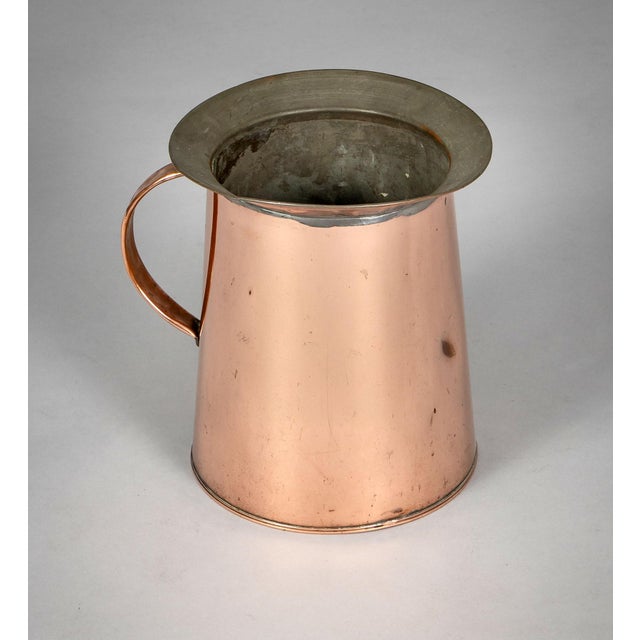 19th Century copper pitcher with handle and wide rim, designed with clean simple lines. The inside is tinned. The bottom...