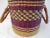 Well made African woven basket in shades of purple, magenta and tan with leather wrapped double-handles. Excellent condition.