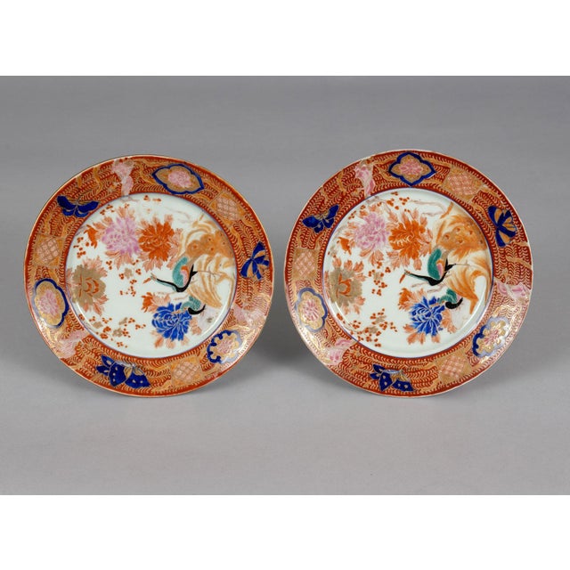 A boldly patterned pair of 19th Century Chinese plates decorated with peacocks, orange, blue and pink chrysanthemums,...