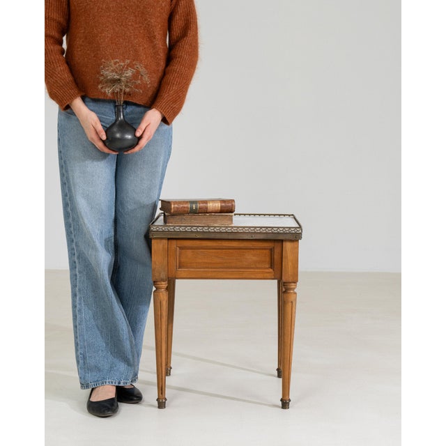 This table makes its impression through natural honey oak, tapered turned. Originating in France during Early 20th...
