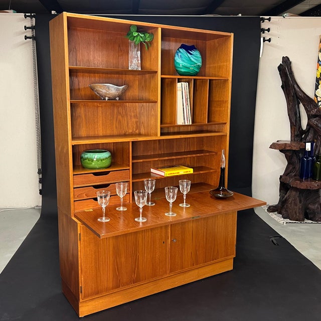 A wonderfully versatile piece of Danish design that functions as bookcase, bar, and writing desk in one sculptural form....