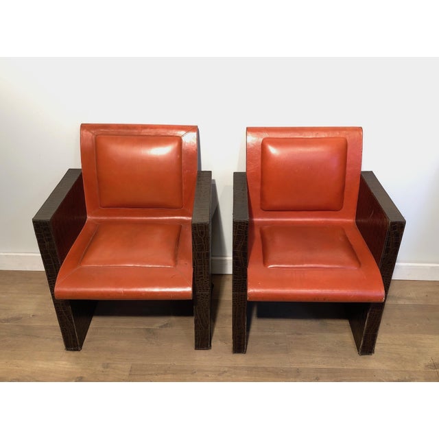 This very unusual pair of armchairs is made from an orangeish and brown leather. The armchairs can be sold individually,...