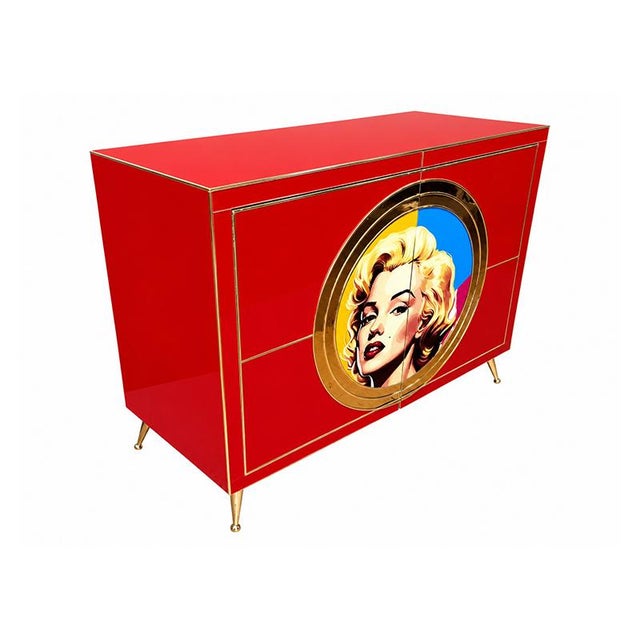 Sideboard with a strong visual impact, inspired by Pop Art and Hollywood glamour. The bright red lacquered structure is...