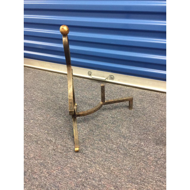 Offering a pair of brass French wrought andirons which came from Paris in the 1940's.