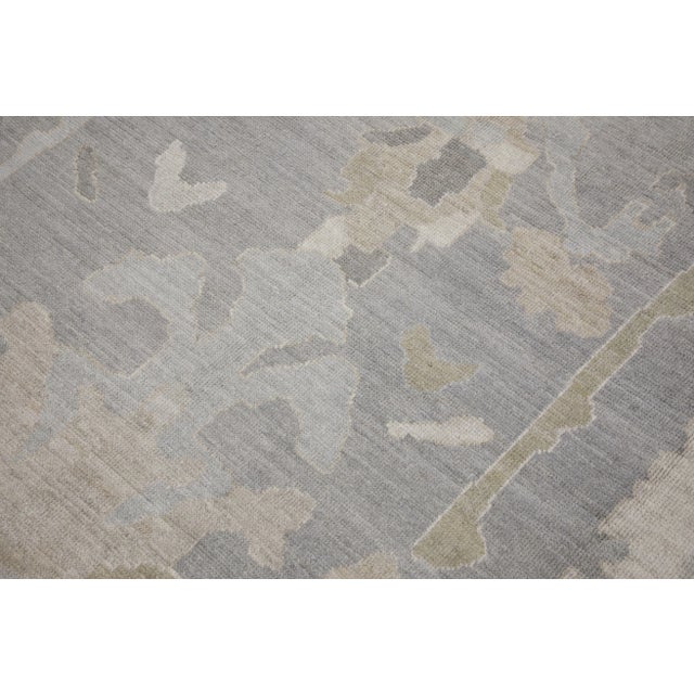 This modern Turkish Oushak rug is a stunning piece of art that has been handwoven using traditional techniques by skilled...