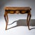 Elegant games table standing on cabriole legs, veneered in burl wood and fitted with bronze mounts in the form of rocaille...