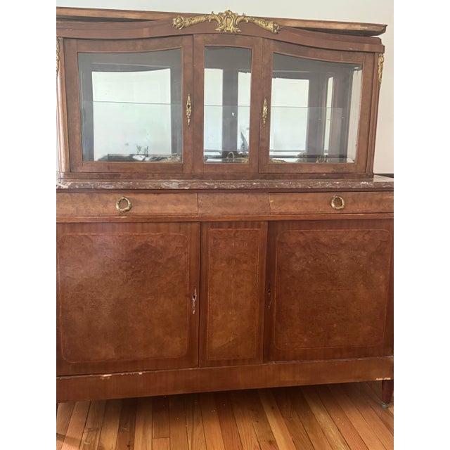 Beautiful vintage French-style burl wood china cabinet with curved glass display top and spacious lower storage. Features...