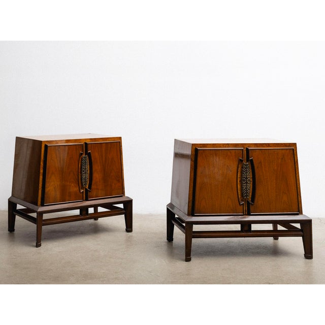 A pair of mid century nightstands by Genova Furniture Company. A warm lacquered walnut finish, burl wood accents, tapered...