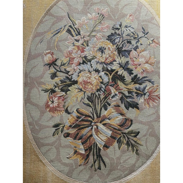 Elegant woven floral tapestry wall hanging featuring a lush central bouquet tied with a striped ribbon and framed within...