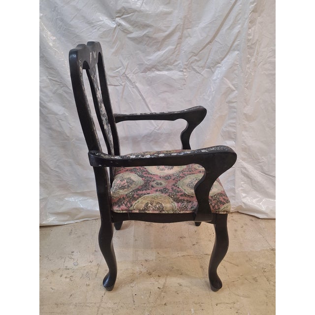 Antique Chinese export armchair features exquisite mother-of-pearl inlay set into a rich black lacquered wood frame. The...