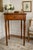Beautiful vintage solid wood side table featuring elegant turned legs, a single drawer, and rich warm wood grain. Likely...