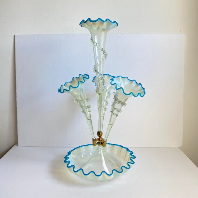 A Victorian blue vaseline glass epergne, having a central stem and three lily form trumpets with turquoise blue petals...