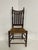 An early American spindle back elm wood side chair with a woven herringbone patterned rush seat, tall straight vertical...