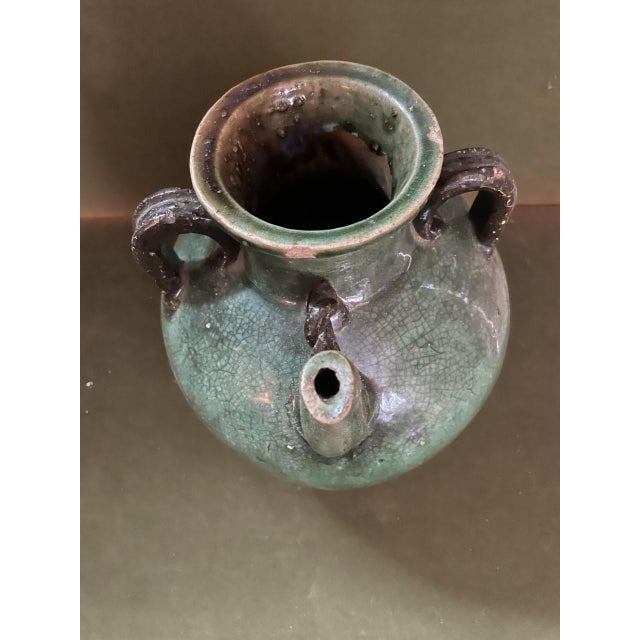 19th century French Fiance three handled pottery jug in a deep green glaze with hints of cobalt blue and a rope twisted...