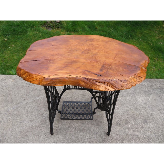 Very nice antique cast iron Singer treadle sewing machine base with nice older live edge cedar wood top. The table is...