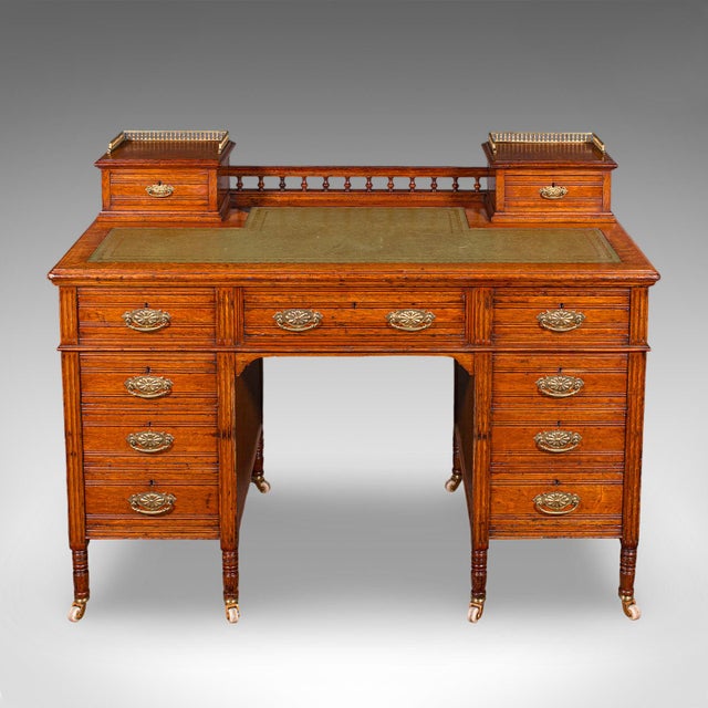 This is an antique estate manager's kneehole desk. A Scottish, golden oak and leather office desk, dating to the late...