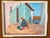 The painting is a bright, expressionistic oil painting of a village scene with a seated figure on a reddish chair in front...