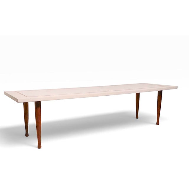 Sophisticated architectural Mid Century coffee table, having a rectangular cast stone top with wood pencil inlay trim, the...