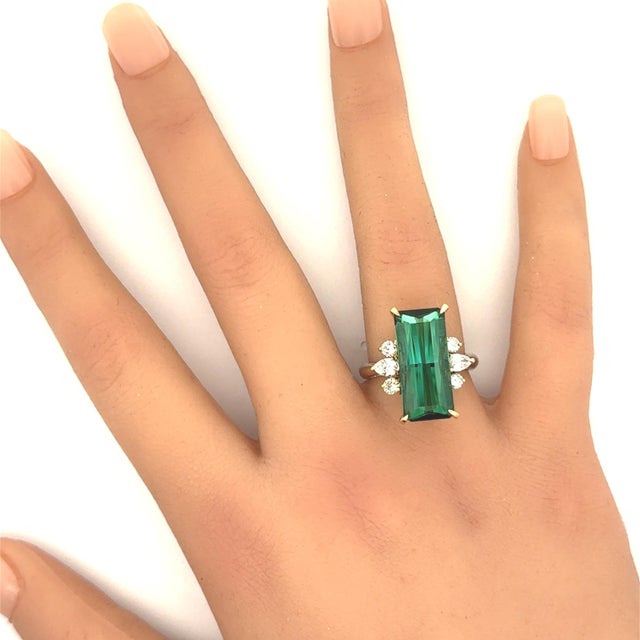 A captivating tourmaline weighing 9.68 carats is the centerpiece of this exquisite ring. It features a baguette-cut...