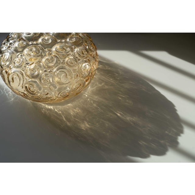 A pair of mid-century bubble-glass flush mounts in a spiral or snail design that can be fixed flat to either a ceiling or...