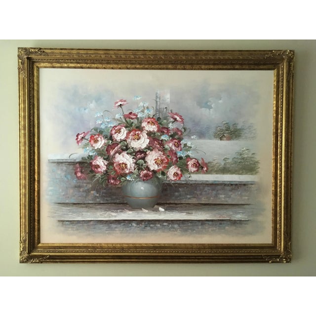 Vivid colors of flowers on steps with a cottage in the background.