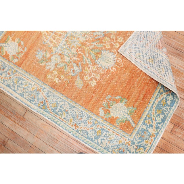 An early 20th-century orange field antique Oushak scatter size rug Measures: 3'7” x 4'10”.