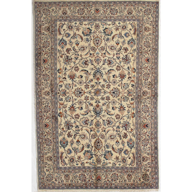 Antique hand-knotted Persian Mashad wool rug with an ivory field featuring a dense allover floral pattern of scrolling...