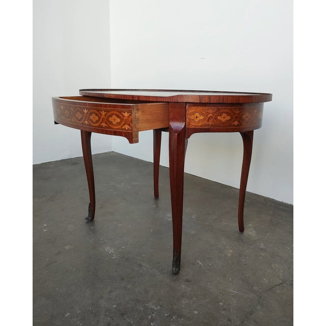 A French Louis XVI mahogany oval side table with hidden drawer and starburst veneer top, with a trellis motif around the...