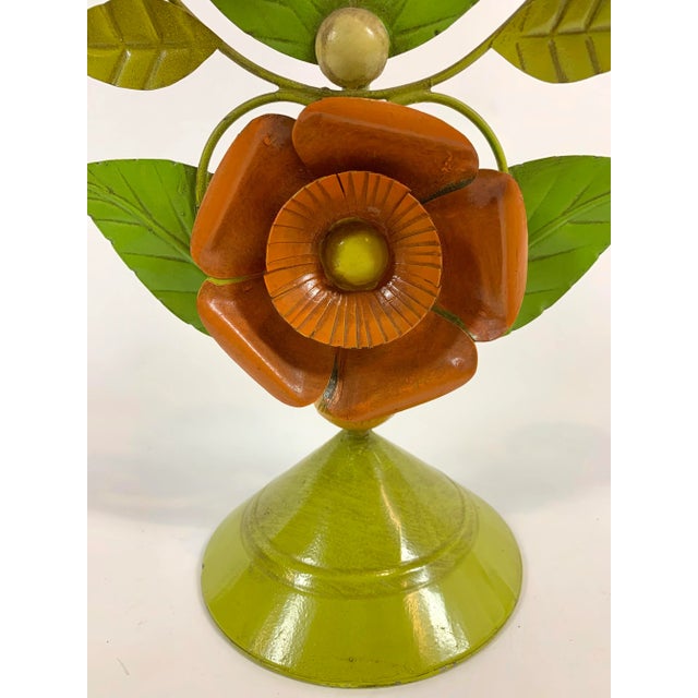 A mid century modern painted tole candelabra with floral motif. Holds three candles