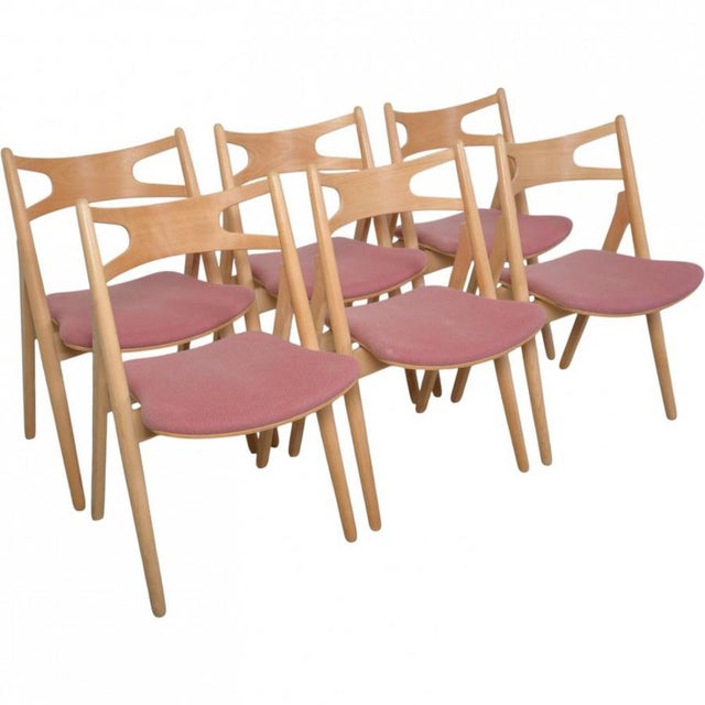 Set of 6 Hans Wegner sawback chairs with frames of beech and seats upholstered in fabric. The chairs are from 1995 and...