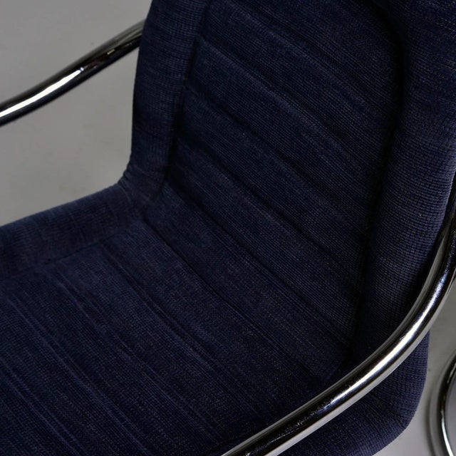 Found in Italy, this pair of circa 1970s armchairs feature polished chrome frames with a circle form base and curved arms....