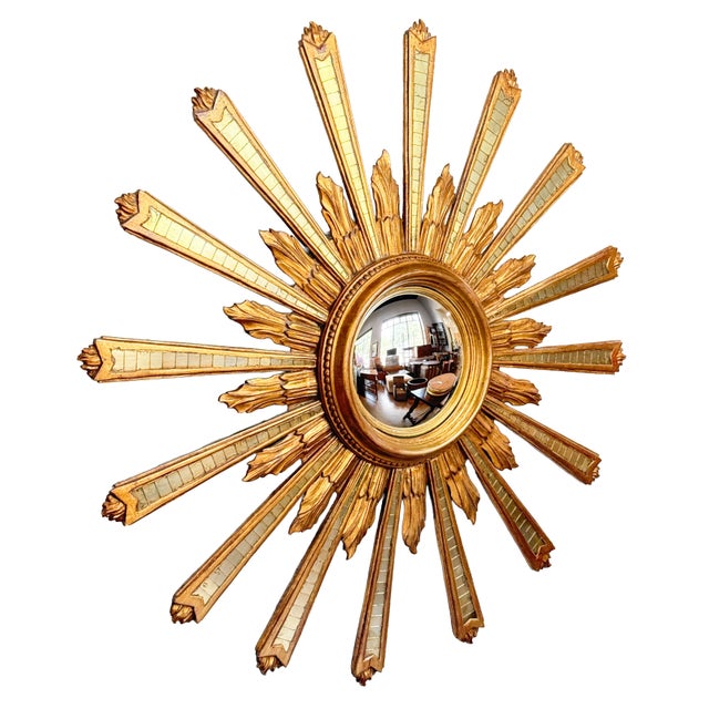 A beautiful Italian gilt sunburst (or starburst) mirror of large scale, featuring mirrored and giltwood rays of varying...