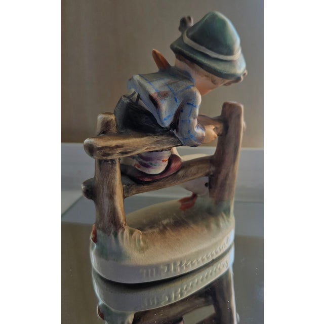 Vintage “Barnyard Hero” Hummel figurine featuring a young boy proudly holding his goose. A classic pastoral design...