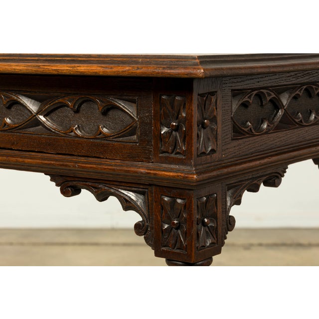 Dating to the late 19th century, this French Gothic Revival writing desk is crafted from solid oak and distinguished by...