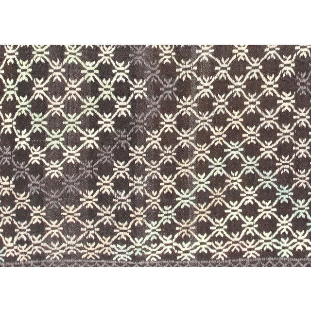 This vintage Turkish Kilim, measuring 7'1" by 8'11", is handwoven with wool on a wool foundation in the Oushak region of...