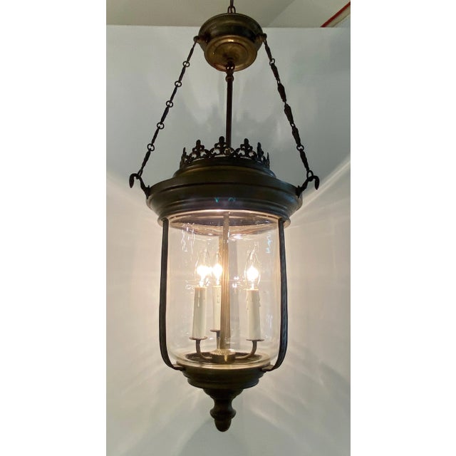Patinated bronze lantern with 3 candelabra lights and hand blown glass shade. Dimensions 17" Diameter 45" Hight\, the...